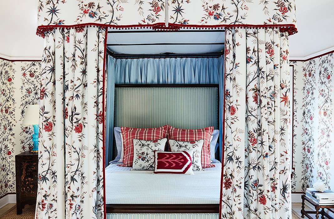 A blue-green stripe serves as a grounding pattern for a bed covered in chintz, plaid, and ikat. Photo by Joe Schmelzer.
