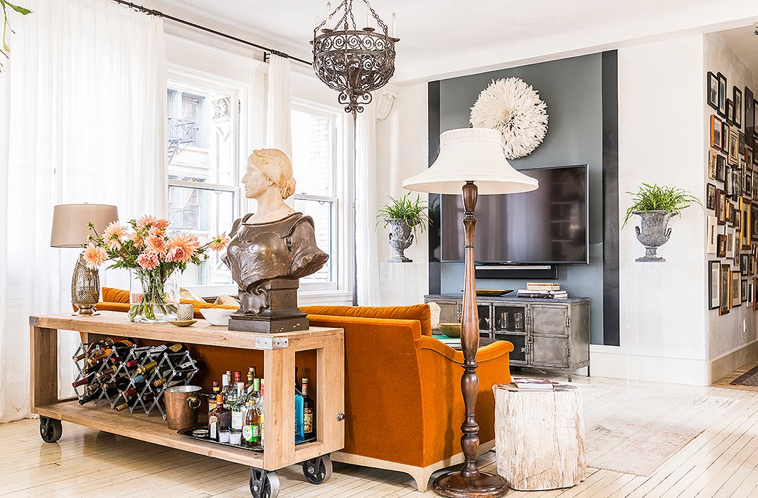 A favorite of the kids, this “supercasual” seating nook is ideal for curling up to Netflix marathons and Sunday football games. To downplay the TV, Katie turned to one of her favorite decorating tricks: a glossy stripe of black paint. Plexiglas pedestals bookend the setup, and a bust of Joan of Arc (“the first antique I ever bought”) keeps watch over the dining area.
