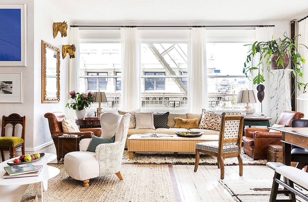 Neutral furnishings complement the white plaster walls in the sunny great room. “I didn’t want it to feel too heavy,” says Katie, who brought in diaphanous white drapes, a spectrum of creams, tans, and browns, and plenty of layered textures to achieve a balance of airy and cozy.
