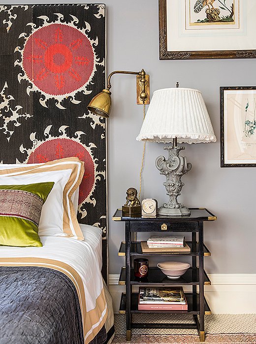 A headboard covered in a large-scale suzani—along with a collection of trinkets from all over the globe—brings worldly flair to the bedroom. Photo by Lesley Unruh. 
