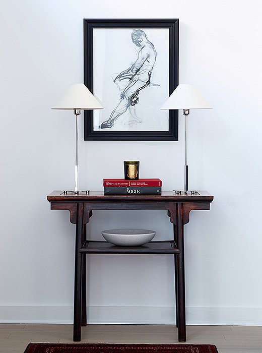 David focused on adding light in another entry vignette. “There’s a flush mount on the 11-foot ceilings, but that was really the only light source. We brought in the two lamps and put them on a vintage Chinese altar table.”
