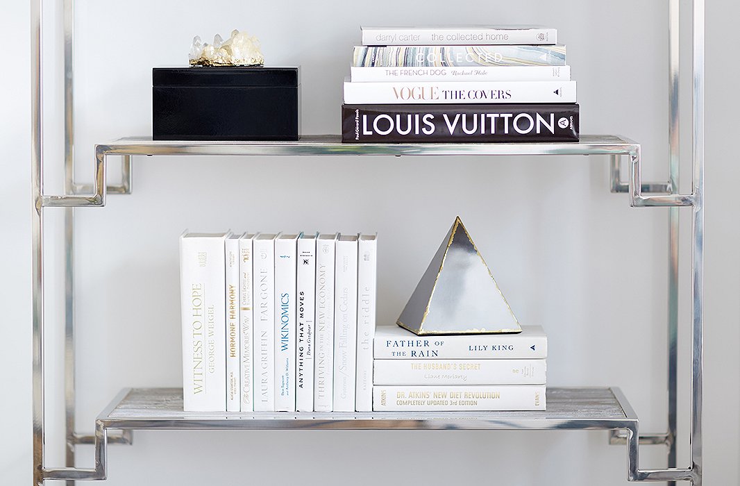 White books and a few geometric accents keep the étagères from feeling cluttered. “I think that there is an interesting tonal play between the books and the wall color,” David says. “Even though the books were published in the ’50s, ’60s, and ’70s, they feel more modern and up-to-date because they’re all color-blocked in one shade.”
