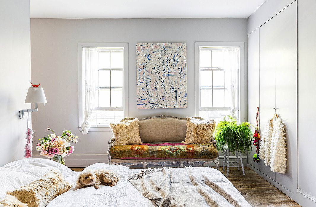 The family’s dog, Noa, relaxes in the master bedroom amid cozy alpaca pillows and throws that Jenni sourced for Intiearth. “I always use white linen for the bed,” Jenni says. “It’s just so clean and soothing. It feels great in winter and summer, and I think it looks even prettier when it’s wrinkly.” She scored the settee for $100 and recovered it in a natural linen.
