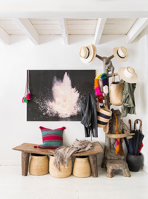 Hats and bags from Jenni’s online textiles shop, Intiearth, hang on a carved coatrack besides a photograph by Hans Gissinger in the entryway. “We don’t wear shoes in the house, so everybody has a basket they put their shoes in.”
