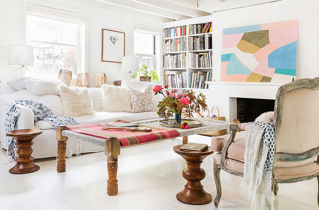 The living area is awash in light and filled with cozy spots to curl up and relax. “The sofa is very comfortable,” Jenni says. “That was a requirement, actually.” (For a similar sofa, see the Liza.) To perk up the white space she used soft pinks, including a painting by her friend Meghan Petras and a frazada, or Peruvian rug, from Intiearth, which she draped over the Indian daybed that serves as a coffee table.
