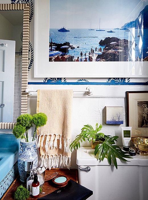 Instead of installing wallpaper, William used a stencil on the bathroom walls. “I knew I wanted to incorporate blue in the space, and I’m obsessed with block print,” he says. He also spray-painted the sink in a coordinating shade and added a skirt to hide storage for towels.
