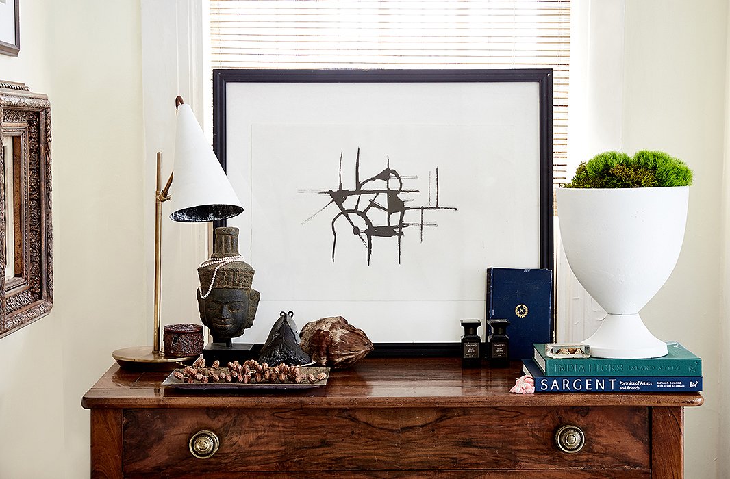 William paired one of his artworks with a modern lamp and vase for a graphic vignette atop a chest of drawers in the living room. “I don’t use overhead lighting a lot,” he says. “I have, like, a million lamps in the house.”
