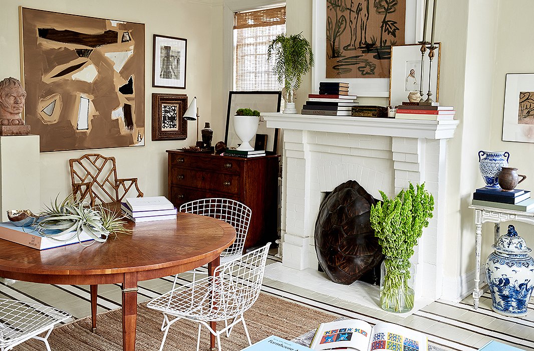 White Bertoia chairs surround the refined dining table, which also serves as a spot to display books and set keys and groceries down. “I like mixing antiques and traditional pieces with a little bit of modern,” William explains. “Everything’s much less predictable. It makes it look collected.”
