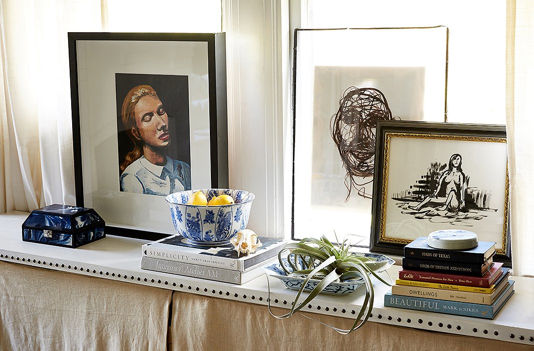 William created a radiator cover using linen and nail-head trim, transforming the windowsill into an additional spot to display art and books.
