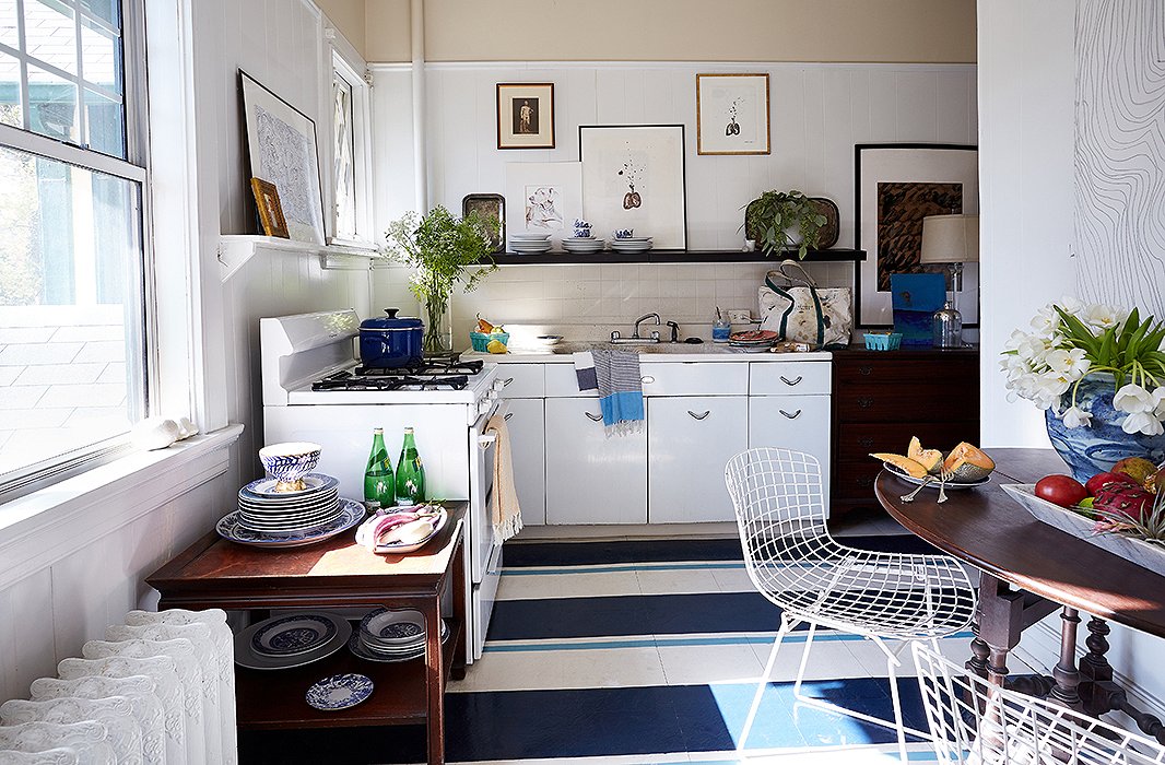 The kitchen’s linoleum floor received a bold makeover. “Painting a floor is a way to add color, pattern, and interest in a space that normally doesn’t have patterns or upholstery in it,” William says. He kept the shelving open so that he could display his china and other collections.
