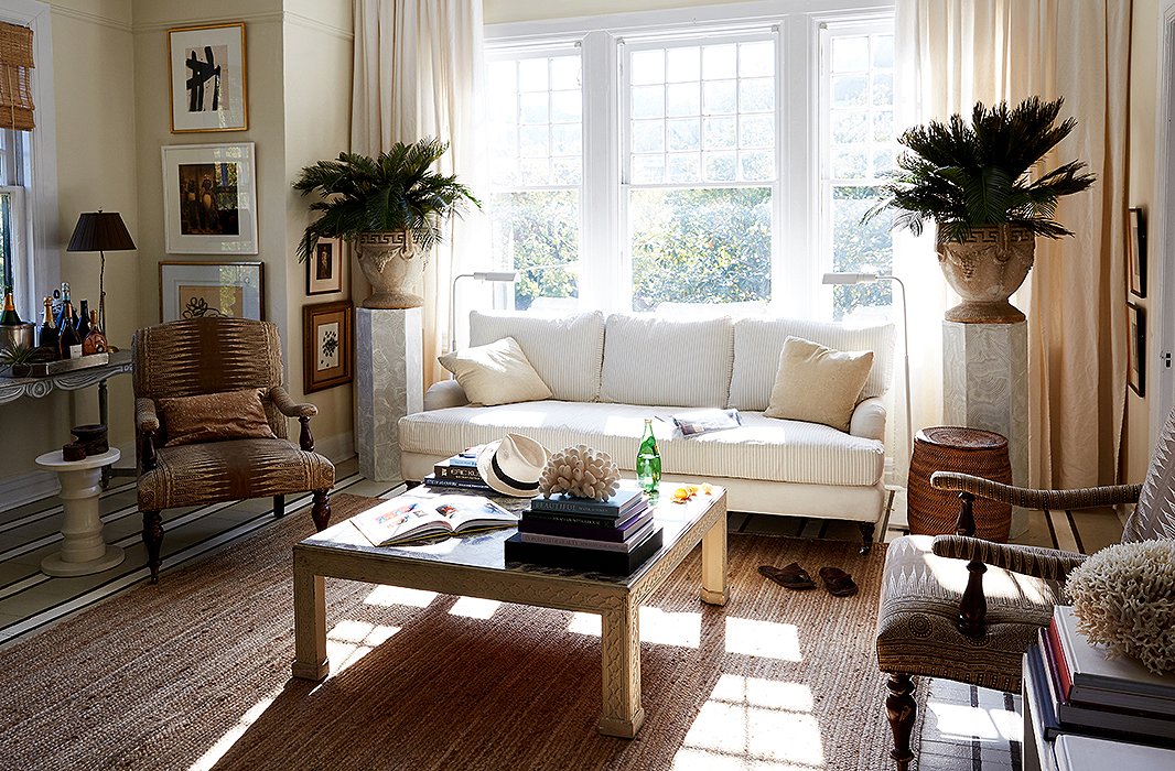 A pair of marbleized pedestals topped with plants in neoclassical urns frame a sofa in perfect symmetry. Photo by Frank Tribble.
