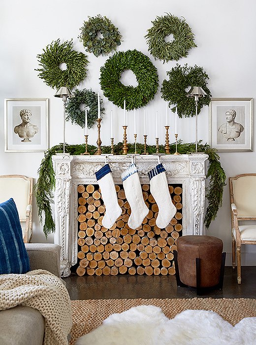 The gallery wall goes green in this inventive look, which feels all the more charming thanks to a fireplace stacked to the brim with logs and hung with shibori-accented stockings. Photo by Tony Vu.
