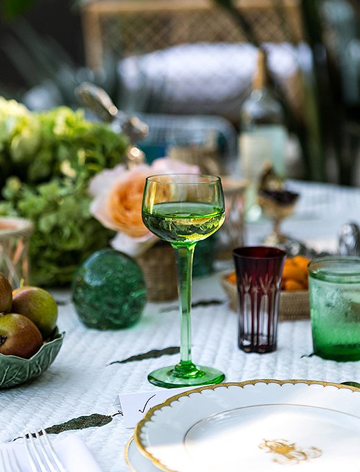 “I love nothing more than colored glasses,” says Rebecca. Accented with deep-red juice glasses, the green goblets and tumblers play off the verdant surroundings.
