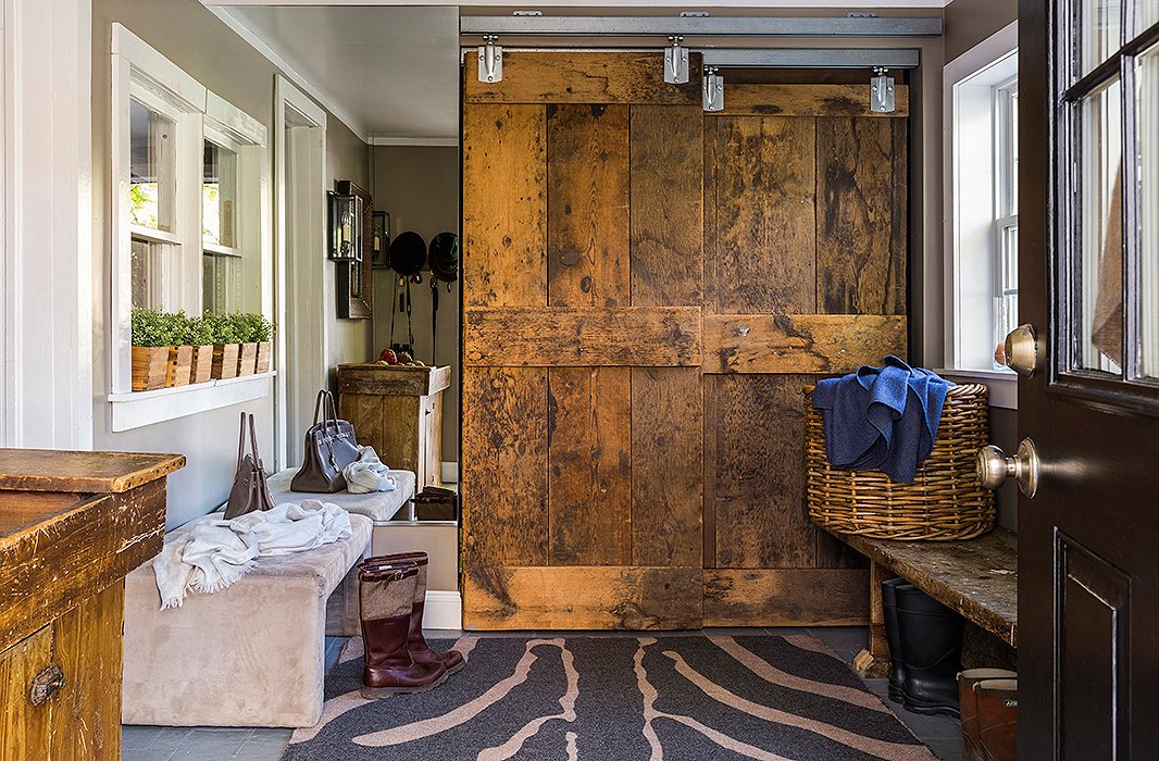 “With four kids you just have to be flexible and well organized, so we created this knowing that they’re going to all come in with muddy boots,” Alicia says of the mudroom, which is outfitted with a closet concealed by a custom-made barn door and bins for each member of the family. “Is it always tidy? No, not always, but we try.”
