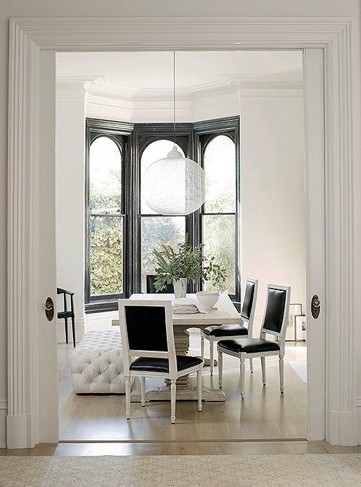 Black and white paint gives the home’s traditional architecture a modern edge. Walls (flat) and trim (high gloss) in Benjamin Moore’s White Wisp. Window frames in Benjamin Moore’s Black, high gloss.
