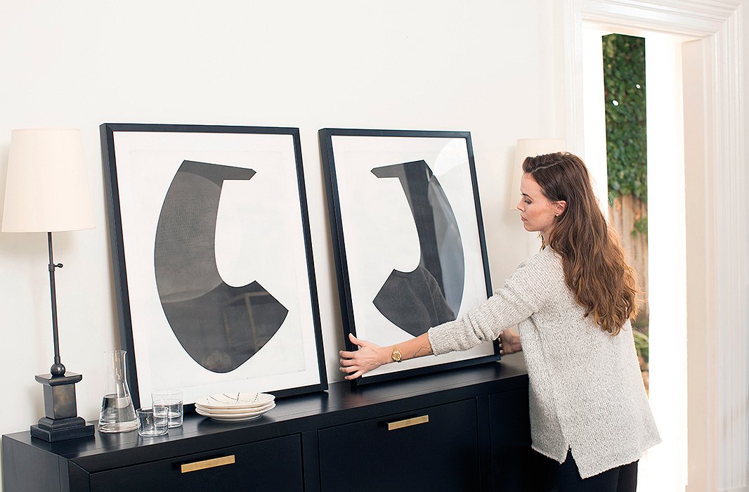 Erin loves the look of leaning art, so Chelsea placed a pair of large prints atop the sideboard. “It feels a little undone but kind of cool and intentional,” says Erin. It’s also a practical choice. Putting a nail in delicate plaster walls can be a risky feat—and once done, there’s no changing your mind. 