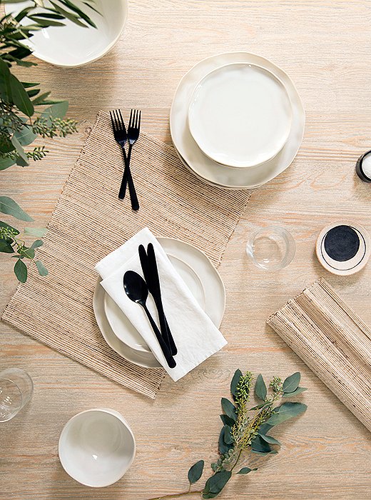 Modern flatware contrasts with earthy ceramics on the table. “I love that juxtaposition of really stark and modern and something with more of an organic edge,” Erin says.
