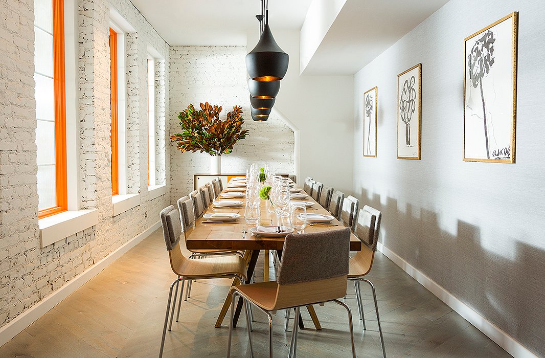 Dan chose to paint the window frames a bold orange to complement the Tom Dixon pendant lights and the Arthur Krakower prints, which he chose with the help of One Kings Lane Interior Design.
