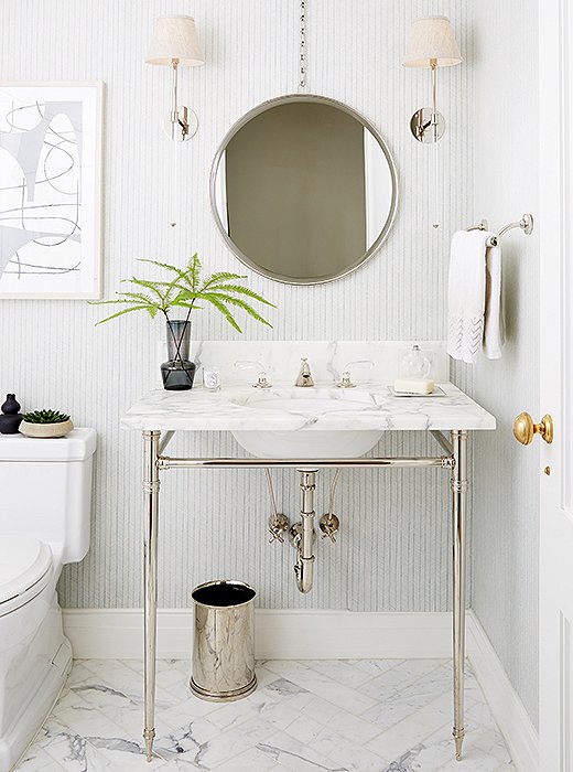 The subtle wallpaper was the starting point of the powder room. “We wanted something that was feminine but a bit masculine at the same time because it’s five boys to one woman,” says Vivian. “We also put marble on the floor and then carried that through with the vanity to keep a clean but warm feeling.”
