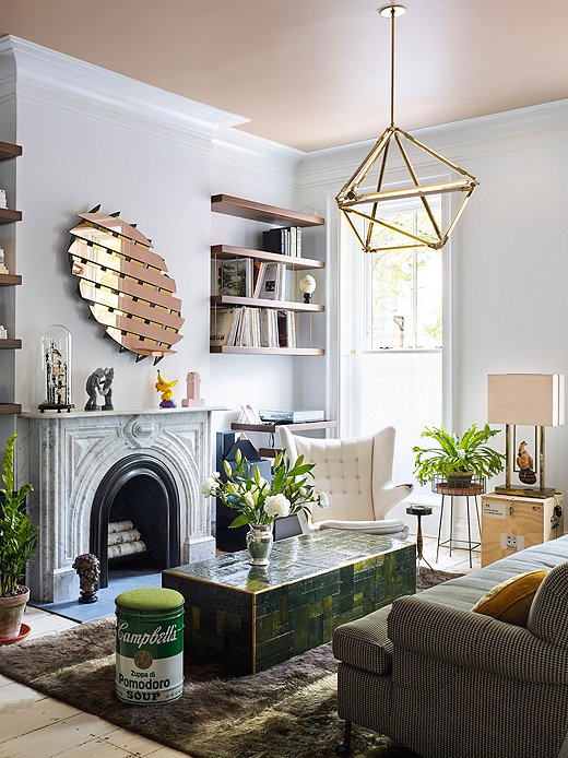 The formal sitting area on the second level mixes modern art with traditional silhouettes. Olivia ensured that all of her high-design pieces, such as the green coffee table from Dutch artisan Piet Hein Eek, were kid-friendly.
