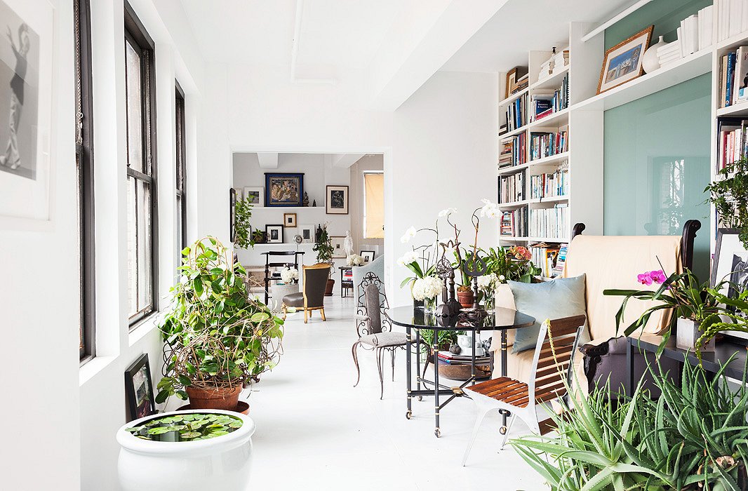 Like his own private conservatory, Vicente’s lush dining area also doubles as his library. The sofa is a 19th-century French find; casters make the table easy to move.
 
