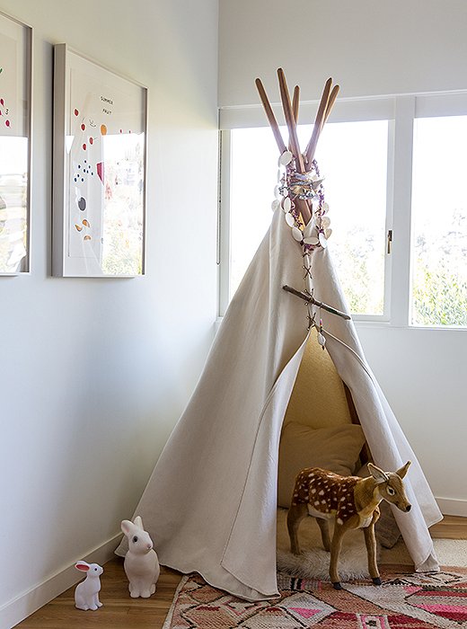 A tepee from House Inhabit commands one corner of James’s room, filled with “a collection of pillows, a sheepskin, and a revolving door of animals, dolls, and often our dog, Blue,” Jessica says.

