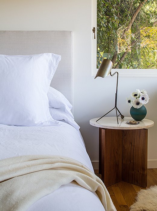 Atop the nightstands, designed and built by Jed, are fountainhead desk lamps from Doug Newton for Nightwood. A surprise pop of color comes courtesy of a vase by a friend, ceramicist Victoria Morris.
