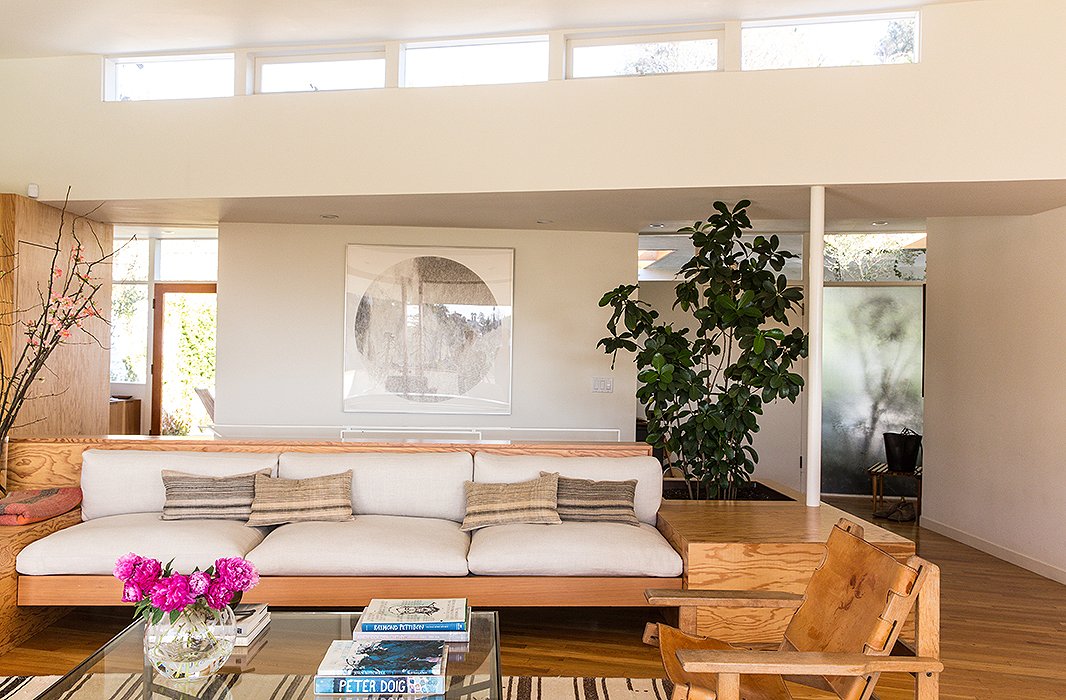 The built-in sofa is the focus of the living room, accented with vintage-linen custom-made pillows. “We like a mix of solids and patterns,” says Jessica. “And we’re really drawn to washed linens and ethnic prints.” The large circular artwork is by Russell Crotty, a California artist and friend.
 
