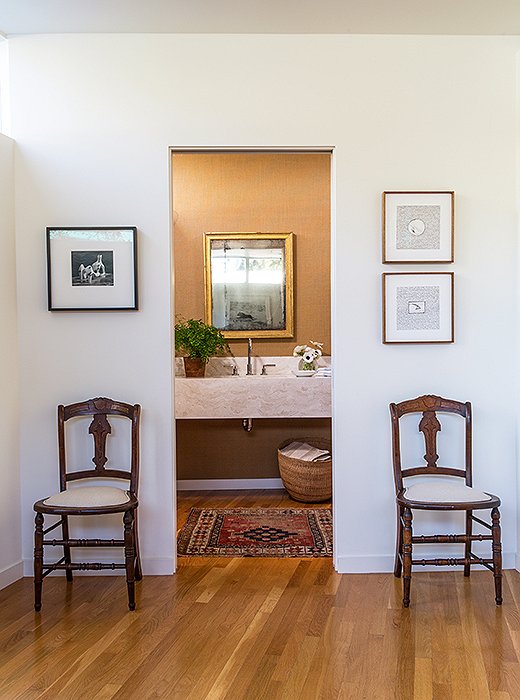 The powder room pairs “traditional with modern pieces”—a mix the couple enjoys. “It makes it cozier and more comfortable,” says Jessica. Jed’s mother gifted the chairs (upholstered in Libeco linen).
