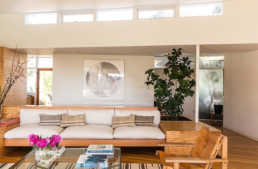 The built-in sofa is the focus of the living room, accented with vintage-linen custom-made pillows. “We like a mix of solids and patterns,” says Jessica. “And we’re really drawn to washed linens and ethnic prints.” The large circular artwork is by Russell Crotty, a California artist and friend. 