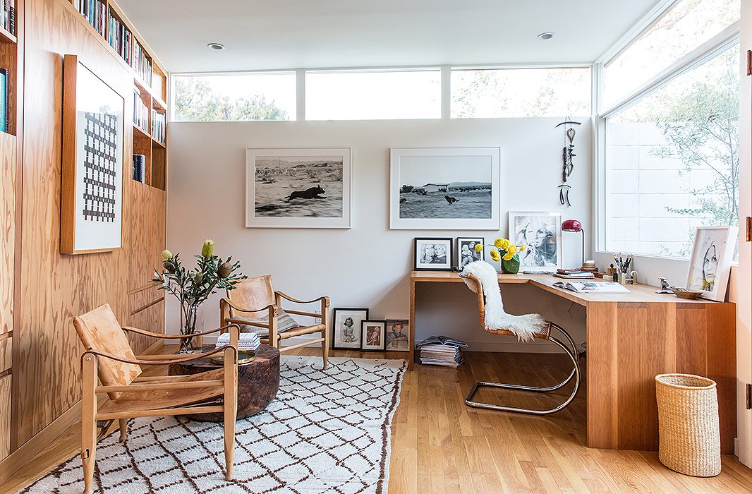 The office doubles as a guest room courtesy of a Murphy bed and side tables hidden in the built-in bookshelves. Jed crafted the L-shape Douglas fir desk. Two Kaare Klint Danish safari chairs flank an Alma Allen table. The photographs are by John Divola.
