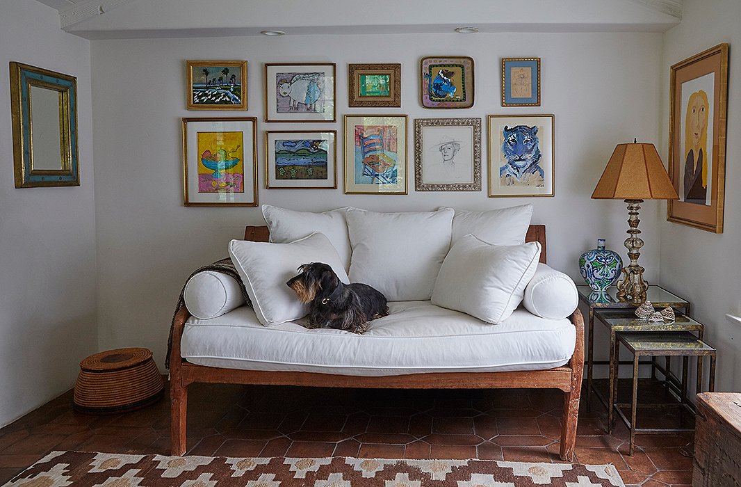 In the office, a wall of personal artwork surrounds an Indian sofa. “There’s a portrait of my grandmother, a colorful monkey my friend painted,, and I did the blue tiger when I was 12,” Kendall says. The Moroccan rug is from a favorite local shop, Upstairs at Pierre Lafond.
