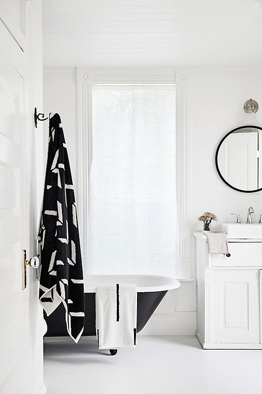 Simple and sleek fixtures play up the original molding and slatted ceiling of the Holly House bathroom.

