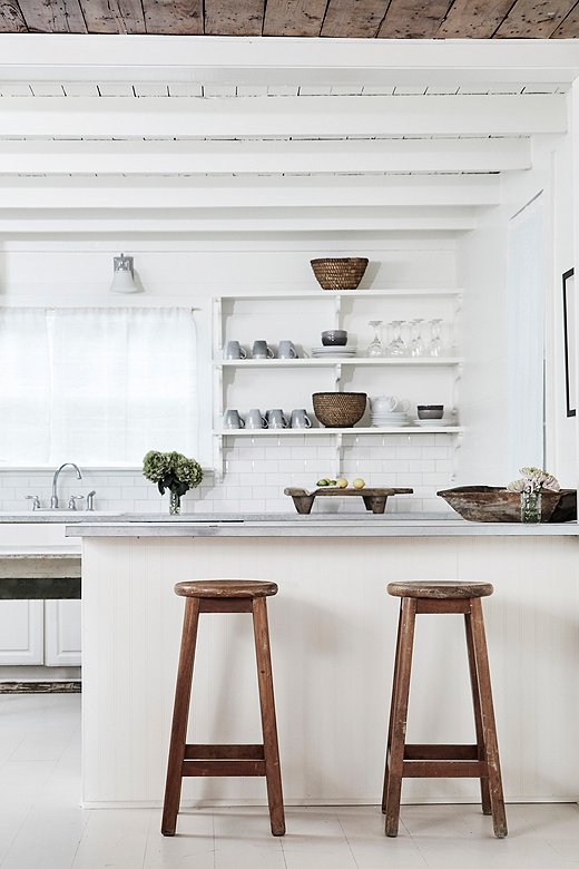 Sleek ceramics, weathered woods, and woven textures give Holly House’s open kitchen a laid-back look.

