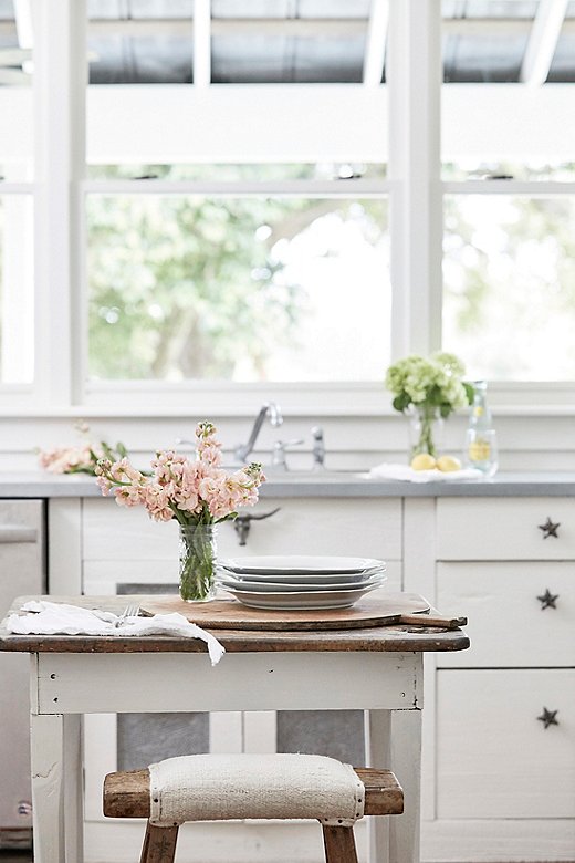 The kitchen in the Farmhouse features weathered wood furnishings, such as the Shandong stool and the petite island shown above, along with star cabinet knobs that nod to the Prairie’s Texas locale. 
