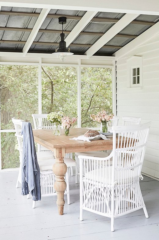 The screened-in porch off the side of the Farmhouse is just one of the five porches that grace the historic structure. 
