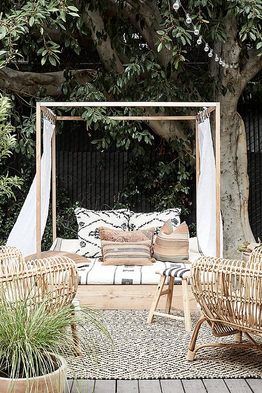 James built this daybed for Kimberly after she gave birth to their daughter Gwendolyn. “It was my own personal triumph over dyslexia. When I was drawing up the plans, I kept worrying that I would transpose numbers and screw it all up, but it came out great,” he said. “Tammy wanted to feature it. She loved the daybed, so I loved her.”  She stacked it high with her pillows and flanked with rattan furniture and one of her signature Shandong benches.
