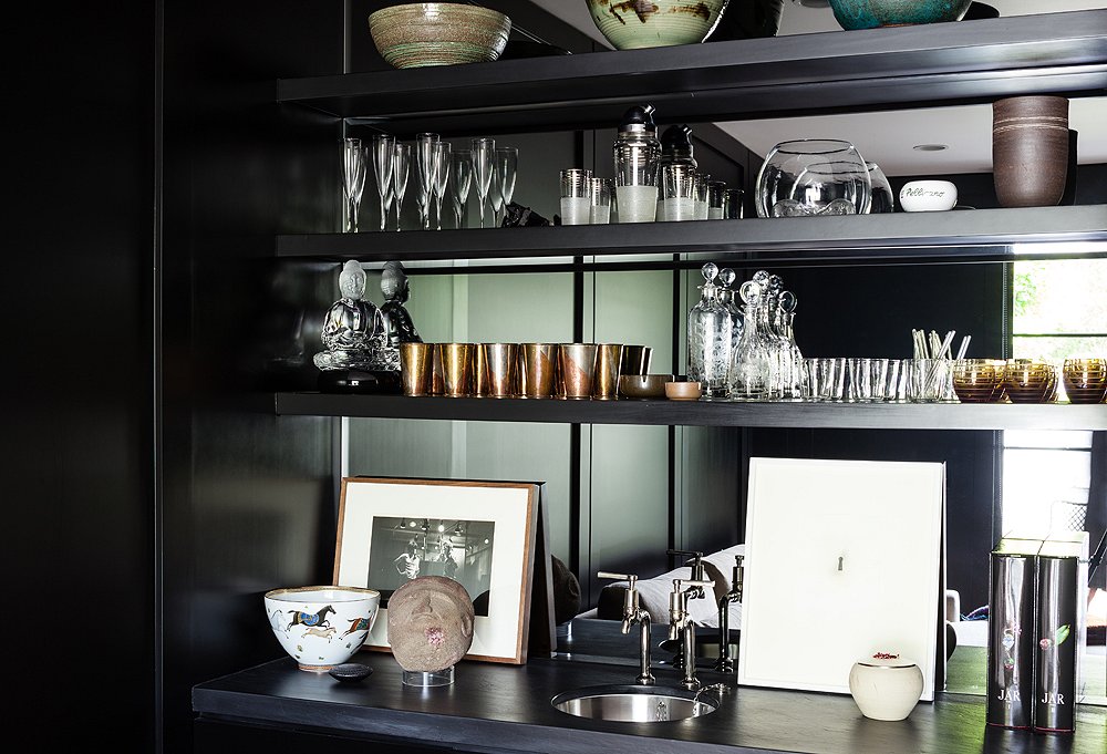 Pottery by Victoria Morris, William Yeoward decanters, Hermès cocktail glasses, and a photo of the Rolling Stones are just some of the items lining the bar. Kayne uses the rose gold, pewter, and brass cups (a birthday present from her mom) for serving drinks and arranging flowers.