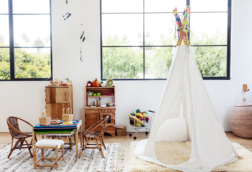 “I love a tepee,” Kayne says. “It’s so fun.” A sheepskin rug adds a cozy layer in a room where everything is kid height and floor play is a regular activity.