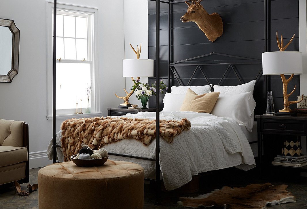The black paneling, nightstands, and canopy bed bring a goth touch to this Western lodge-style room.
