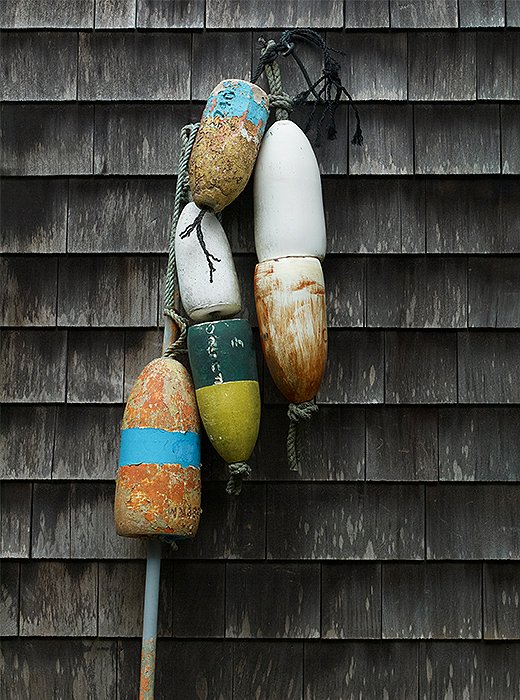 A string of old buoys provides a pop of color against the exterior’s weathered shingles. 
