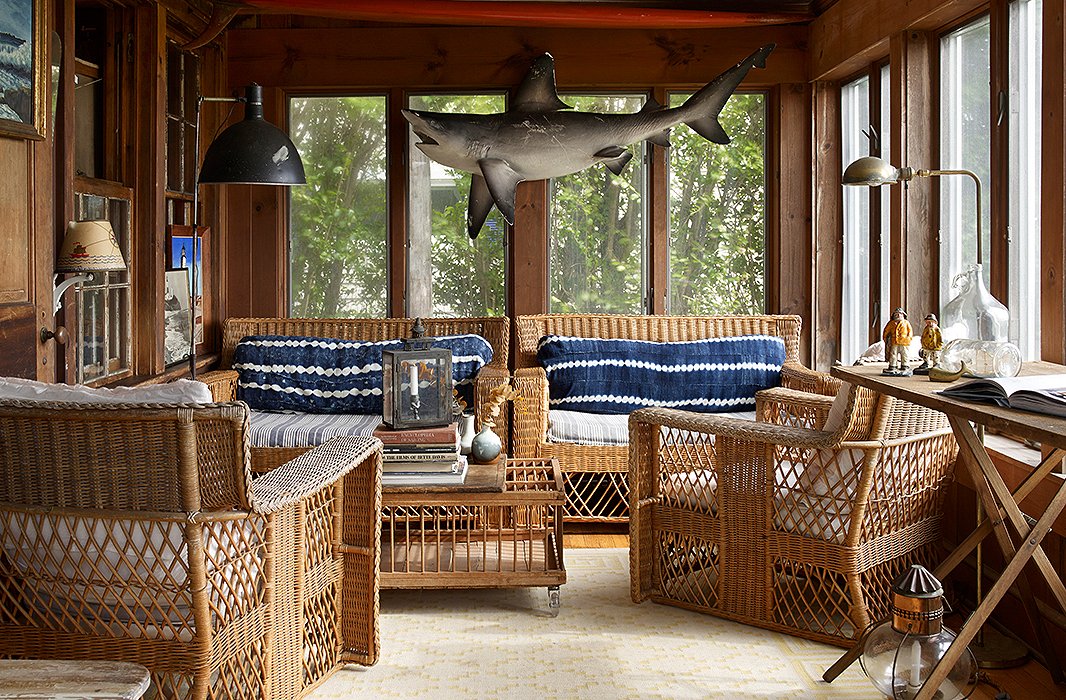 In the sunroom, a wicker sofa and chairs are lined with shibori cushions. The shark is a nod to one of Matt’s favorite films, while the industrial floor lamp adds heft, height, and a sense of scale. 

