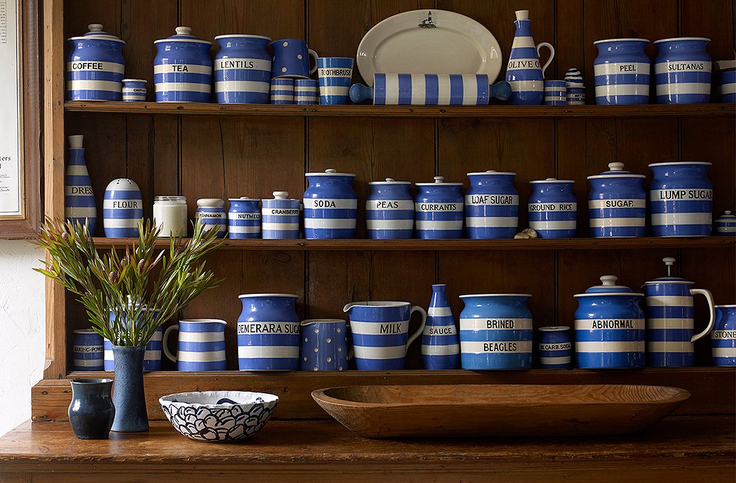 Rows of striped jars hold dry goods on a freestanding pantry made of pine. Simple, functional, and visually appealing, it’s a vignette that proves Lisa Birnbach’s point about a “successful marriage of utility and excellence.” 
