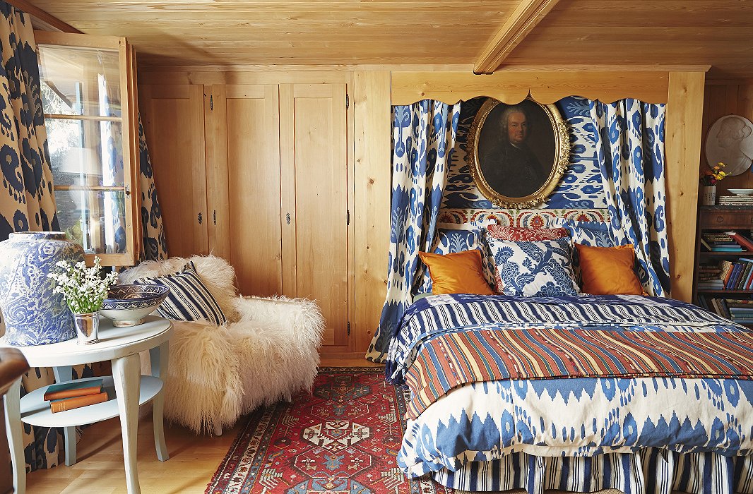 Stripes, ikats, and florals—all in a bold mix of blue and orange—coexist happily in the Gstaad bedroom of one of Michelle’s sons. Solid orange throw pillows and a plush sheepskin chair give the eye a moment to rest.
