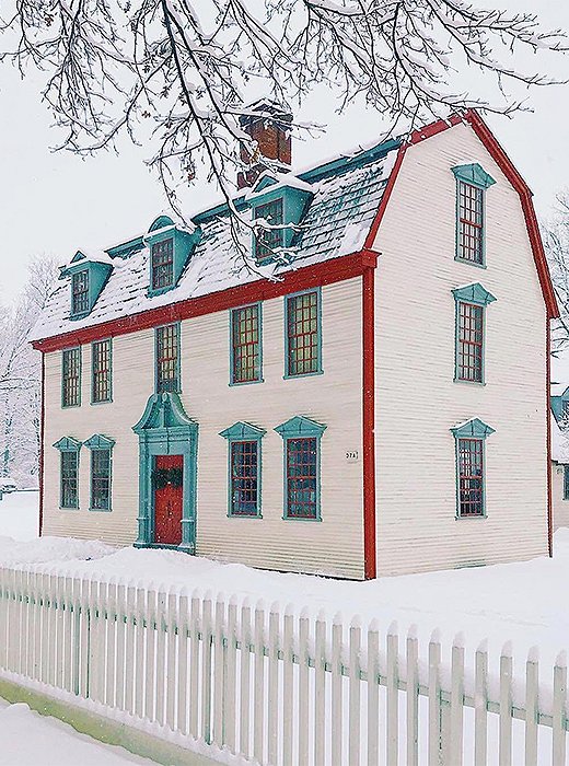 A mansard roof trimmed in red and dusted with snow. Photo by @howieguja.
