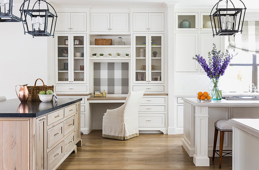 The kitchen now offers a range of spaces for working and for gathering, including two expansive islands and a built-in desk. Marie accented simple Shaker cabinets with wire mesh screens, allowing for a balance of open and closed storage. Photo by Julie Soefer.
