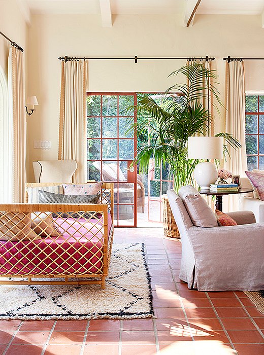 Nicole wrapped a daybed with raffia and anchored it with a Moroccan rug. The pink upholstery is a fashion-inspired hue, which works perfectly with the Saltillo tile floors. 