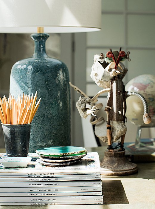 A table lamp by AERIN makes for alluring lighting on Rachel’s desk alongside a wooden sculpture by Haitian artisans.
