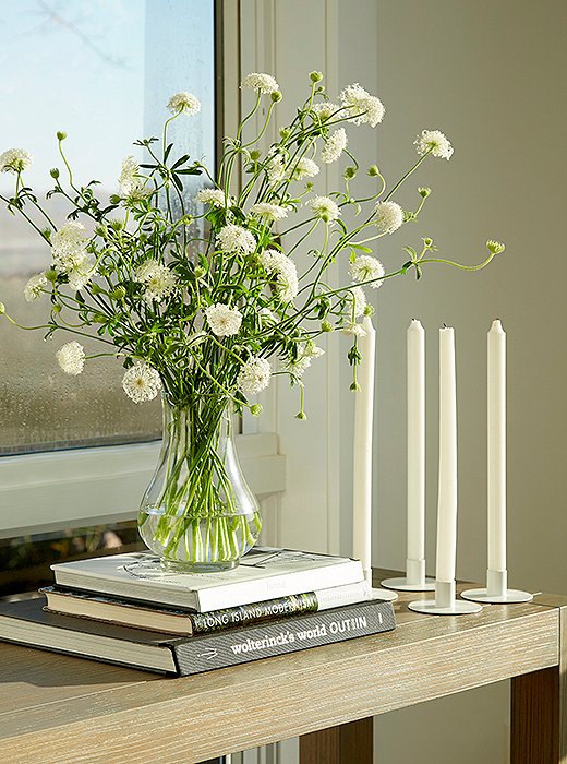 A Parsons-style console in cerused oak is the perfect spot for fresh-cut blooms. Below, two shelves display a few of Foley’s many books, the rest of which are downstairs, organized by category.
