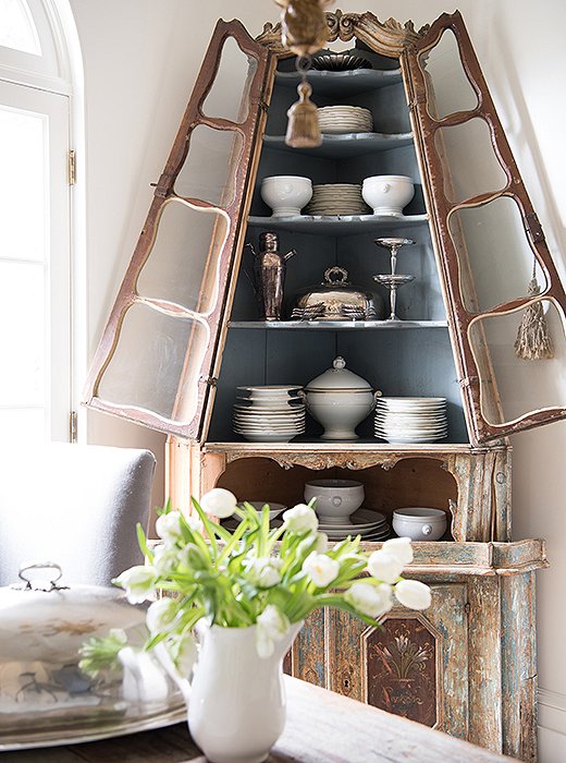 Tara’s collection of white French antique plates pops against the light-blue interior of the antique corner cabinet.
